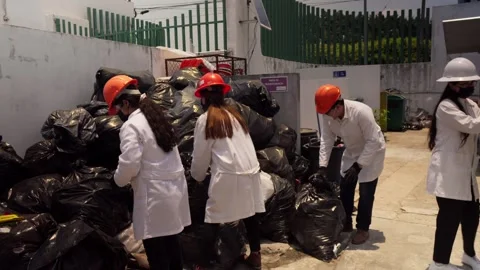 Recycling Plant Workers Handle Waste Bags for Eco-Brick Production Stock Footage 346643921
