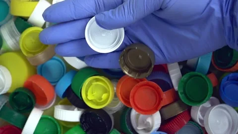 Recycling of plastic bottle caps. The hand drops the caps 스톡 동영상 219999852