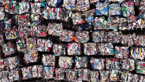 Recycling process showing compacted bales of mixed plastic waste at facility Stock Footage 306486573