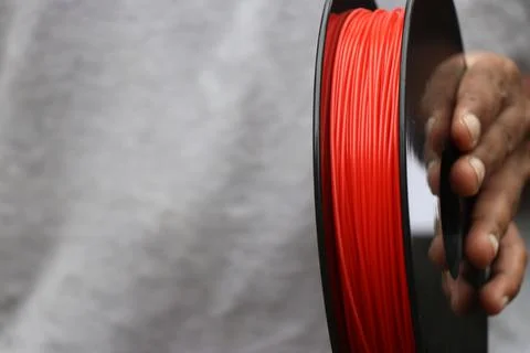 Red 3d printer filament held in hand with space for copy text Stock Photos