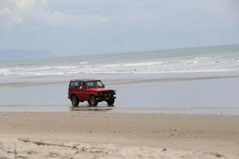 Red 4WD on beach Stock-Fotos