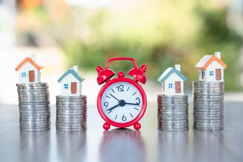 Red alarm clock And houses on stairs, coins, financial concepts, savings, inv Stock Photos