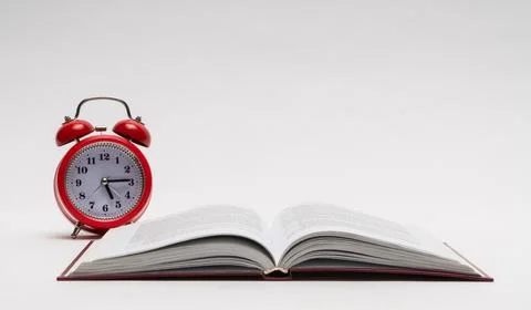 Red alarm clock and open book on white background, isolated. back to school Stock Photos