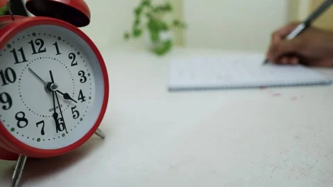 Red Alarm Clock and Writing in Notebook Stock Footage 320726747