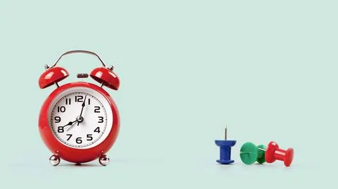 Red alarm clock with multicolor push pins on desk Stock Photos