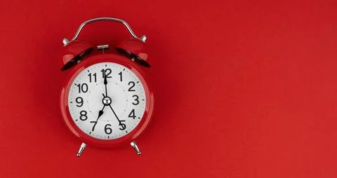 Red alarm clock on a red background. Top view. Stock Photos