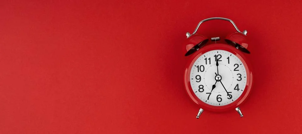 Red alarm clock on a red background. Top view. Stock Photos