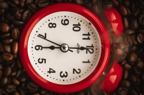 Red Alarm Clock Resting on Roasted Coffee Beans Stock Photos