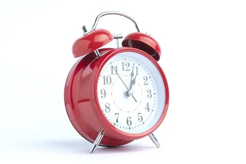 Red alarm clock set at five o'clock isolated on white background. Close-up .. Stock Photos