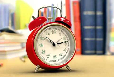 Red alarm clock on study desk Stock Photos