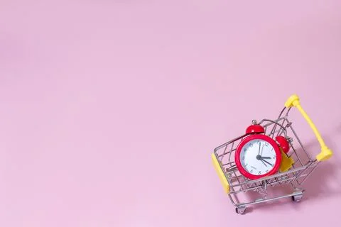 Red alarm clock in supermarket trolley, concept photo of time managment, onli Stock Photos