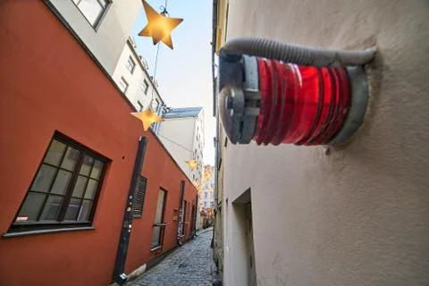 Red alert bulkhead light fixed to a painted yellow orange colour wall backgro 库存照片