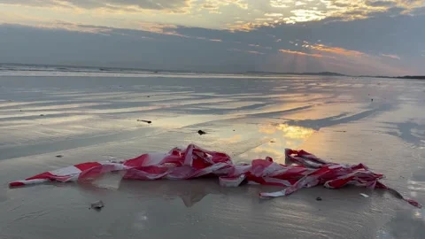 Red amd white plastic tape on a beach Stock Footage 169390401