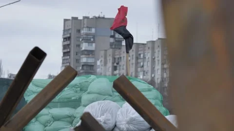 Red and black flag of Ukrainian nationalists is waving on a barricade. Stock Footage 233989927