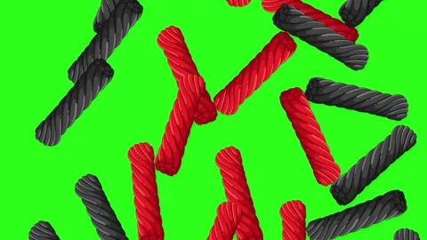 Red and Black Licorice Twists Falling on Green Screen Background Stockbeeldmateriaal 345703609