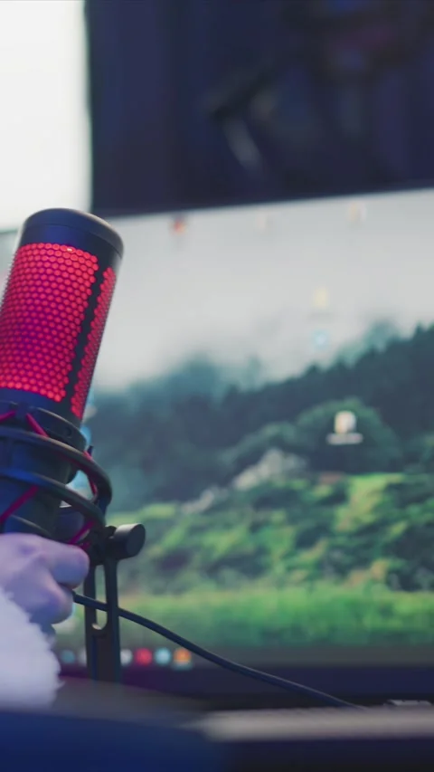 Red and black microphone in front of computer with landscape background showing Stock Footage 346769993