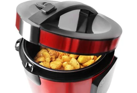 A red and black multi-cooker with its lid raised, revealing raw, diced, sea.. Stock Photos