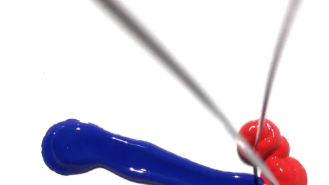 Red and blue paint falling and mixing together on pure white background Stock Footage 72287302
