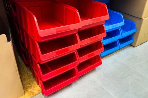 Red and blue plastic boxes for storing small items in a store. Stock Photos