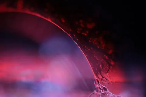 Red and blue reflections of liquid in macro, water surface Stock Photos