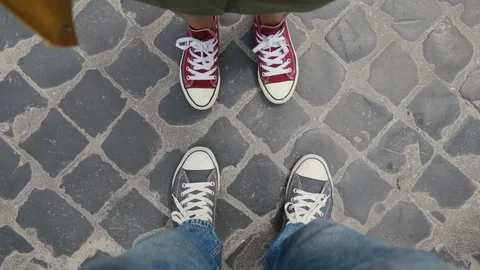 Red and blue sneakers dancing on paving stones. Selfie video taken from above 스톡 동영상 123553218