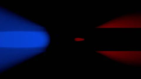 A red and blue stroboscope rotates rapidly counterclockwise against a black Stock Footage 157034900