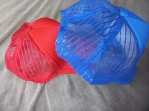 A red and a blue transparent cap are put together with a mesh design. Stock Photos