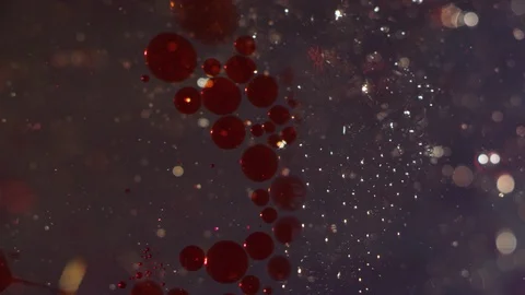 Red and clear bubbles merging together on a liquid bokeh background 動画素材 118287507