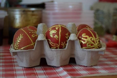 Red and gold decorated Easter eggs in carton tray on folk easter festival Stock Photos
