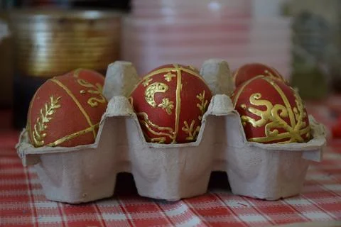 Red and gold decorated Easter eggs in carton tray on folk easter festival Stock Photos