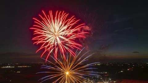 Red And Gold Fireworks Explode Brilliantly In The Night Sky Over A Rural La.. Stock Photos