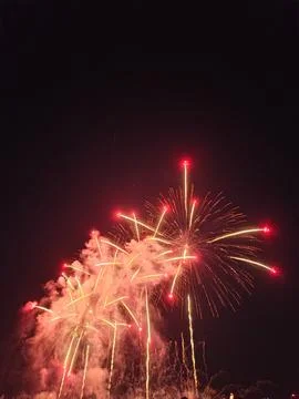 Red and gold fireworks exploding in night sky at Cannes Foto stock