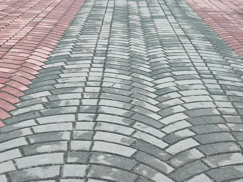 Red and Gray Interlocking Paving Stones in a Curved Pattern Стоковые фото