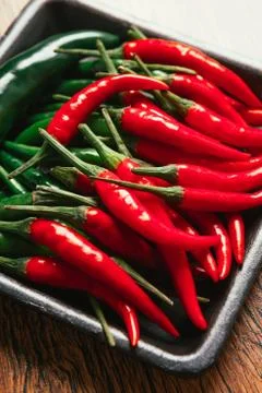 Red and green chili peppers close up on wooden background Stock Photos