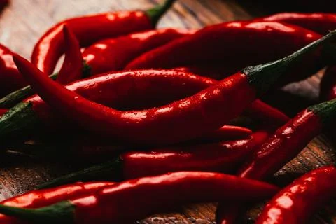 Red and green chili peppers close up on wooden background Stock Photos