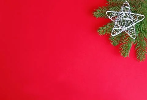 Red and green christmas background with a silver star on spruce Stock Photos