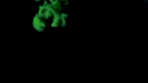 Red and green ink dropped in water from the top isolated on black Video stock 80507040