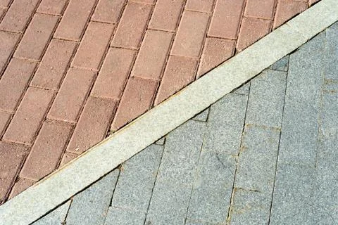 Red and grey pavement bricks separated by white concrete. Stock Photos