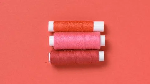 Red and pink thread spools background with copy space for text close-up Stock Photos