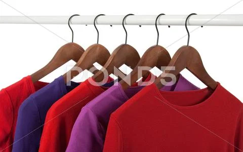 Red and purple casual shirts on hangers Stock Photos