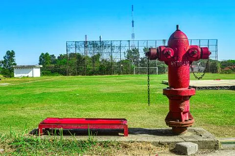 Red and silver fire hydrant against a green grass football field in the bac.. Foto stock