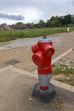 Red and silver fire hydrant on a gravel road in a rural area Photos