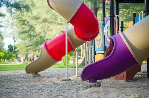 Red and violet pipe slides on modern kids playground Stock Photos