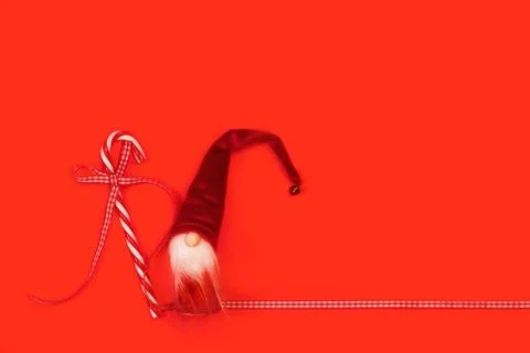 Red and white candy cane and Santa Claus doll on a red background Foto stock