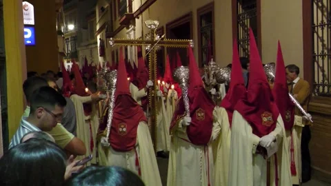 Red and White Capirotes Carrying Crosses at Night in Seville Stock Footage 336007725