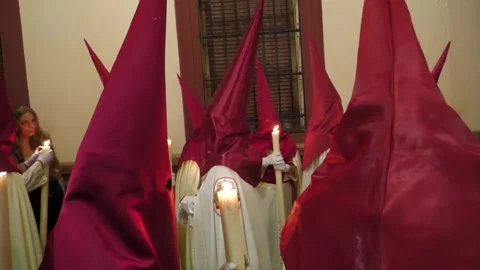 Red and White Capirotes Standing During Night Procession in Seville Stock Footage 336015136