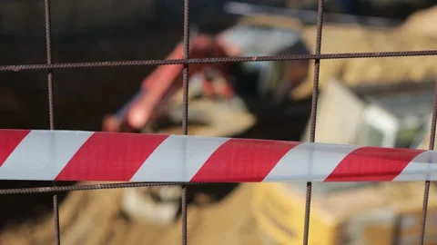 Red and white caution tape on the fence of a construction zone Stock Footage 224681162