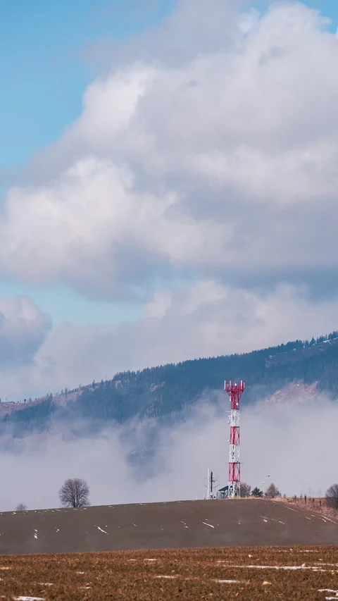 Red and white cell tower above fog Stock Footage 308805295