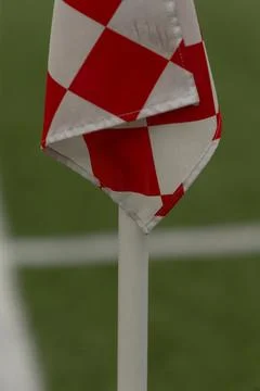 Red and white checkered corner flag on soccer field Stock Photos