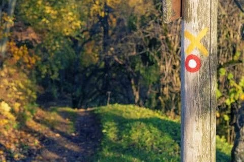 Red and white circular mark on wooden post and trail visible in background Stock Photos